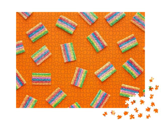 Puzzle 1000 Teile „Bunte saure Gummibärchen auf orangem Hintergrund, Ansicht von oben“