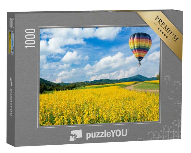 Puzzle 1000 Teile „Heißluftballon über gelben Blumenfeldern, im Hintergrund ein Mittelgebirge“