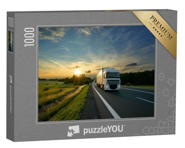 Puzzle 1000 Teile „Weißer Lastwagen fährt auf einer Straße bei Sonnenuntergang“