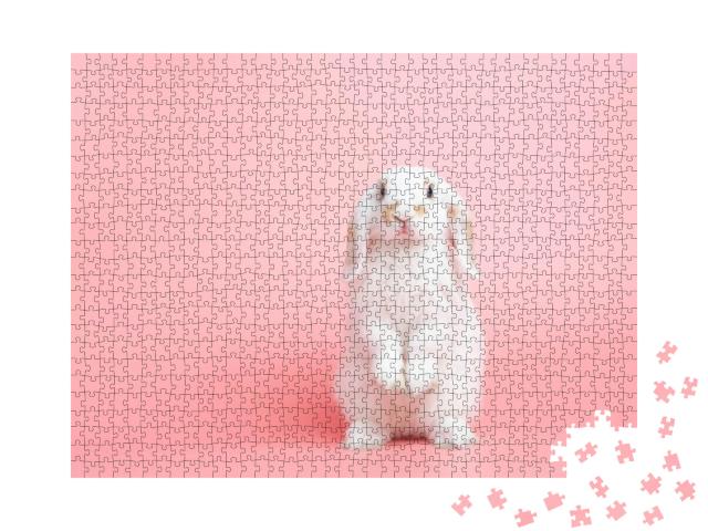 Puzzle 1000 Teile „Ein weißes Kaninchen mit Hängeohren posiert vor rosa Hintergrund“