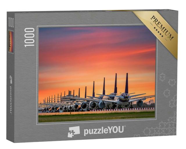 Puzzle 1000 Teile „Geparkte Flugzeugflotte am abendlichen Flughafen“