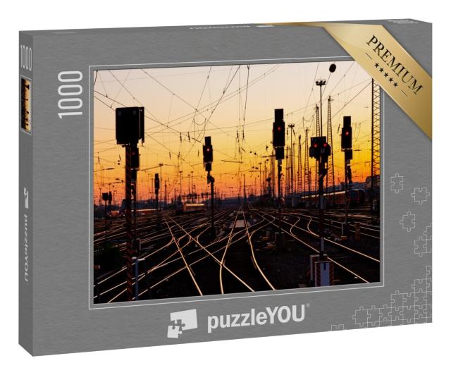 Puzzle 1000 Teile „Eisenbahnschienen in einem großen Bahnhof bei Sonnenuntergang“