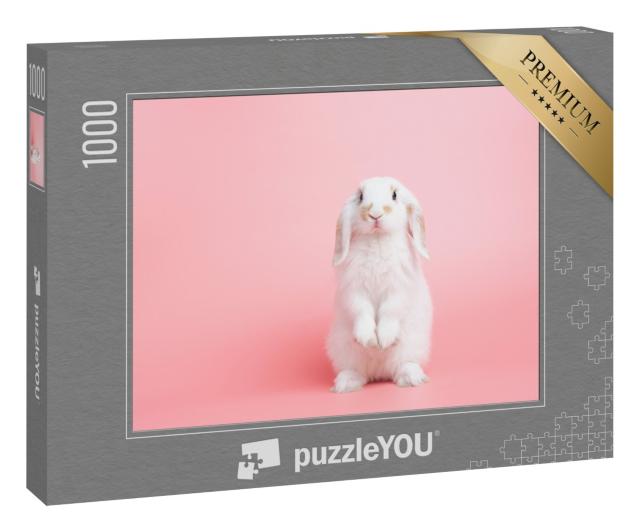 Puzzle 1000 Teile „Ein weißes Kaninchen mit Hängeohren posiert vor rosa Hintergrund“