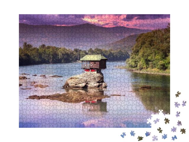 Puzzle 1000 Teile „Buntes kleines Haus auf dem Felsen in der Mitte des Flusses Drina, Serbien“