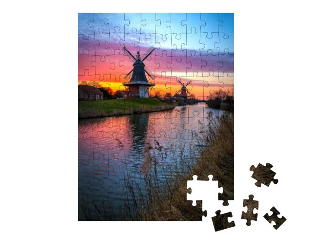 Puzzle 100 Teile „Zwillingsmühlen von Greetsiel, Ostfriesland bei Sonnenaufgang“