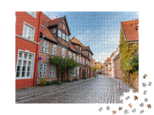 Puzzle 1000 Teile „Straße mit mittelalterlichen alten Backsteinbauten, Lüneburg, Deutschland“