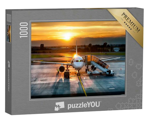 Puzzle 1000 Teile „Passagierflugzeug auf der Landebahn im Sonnenuntergang“